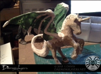 Knightmare Model 01  Project: "I dont' know what I'm doing. 2" Materials: Decopatch extra small 'unicorn' blank figure, strong wire, glue gun, Kneadatite, Paperclay, Silk Clay (though not at this photo's stage yet)  Project link:  "The Daemonslayers"  Character:  knightmare   I had rather a lot of fun with this. Started with a 'extra small' size Decopatch unicorn blank figure.  Pierced through with some thick wire to make the wing base structure, same for the tail. Built up the form with more wire on the wings and lots of hot glue using my trusty glue gun.  I ought to have taken some photos at that stage but didn't think to. Once that was all dried I made the wing membranes out of Kneadatite (Green stuff, to modellers). There's probably better substances to make membranes out of - really I was making this up as I went along.  At this stage, where I finally remembered to start taking photos, I've started using 'Paperclay' which is an air-drying clay to start making Knightmare look like himself. I've never used it before but it was mess-free and reasonably easy to handle.  So built up the wing structure with it, filled out his tail, tried to add some definition to his legs and started on his mane. : knightmare, daemonslayers, model, modelling, sculpture, clay, paperclay, silk clay, 3d, oc, original character, dire unicorn, unicorn, alicorn, unidragon, horse, creature, progress image